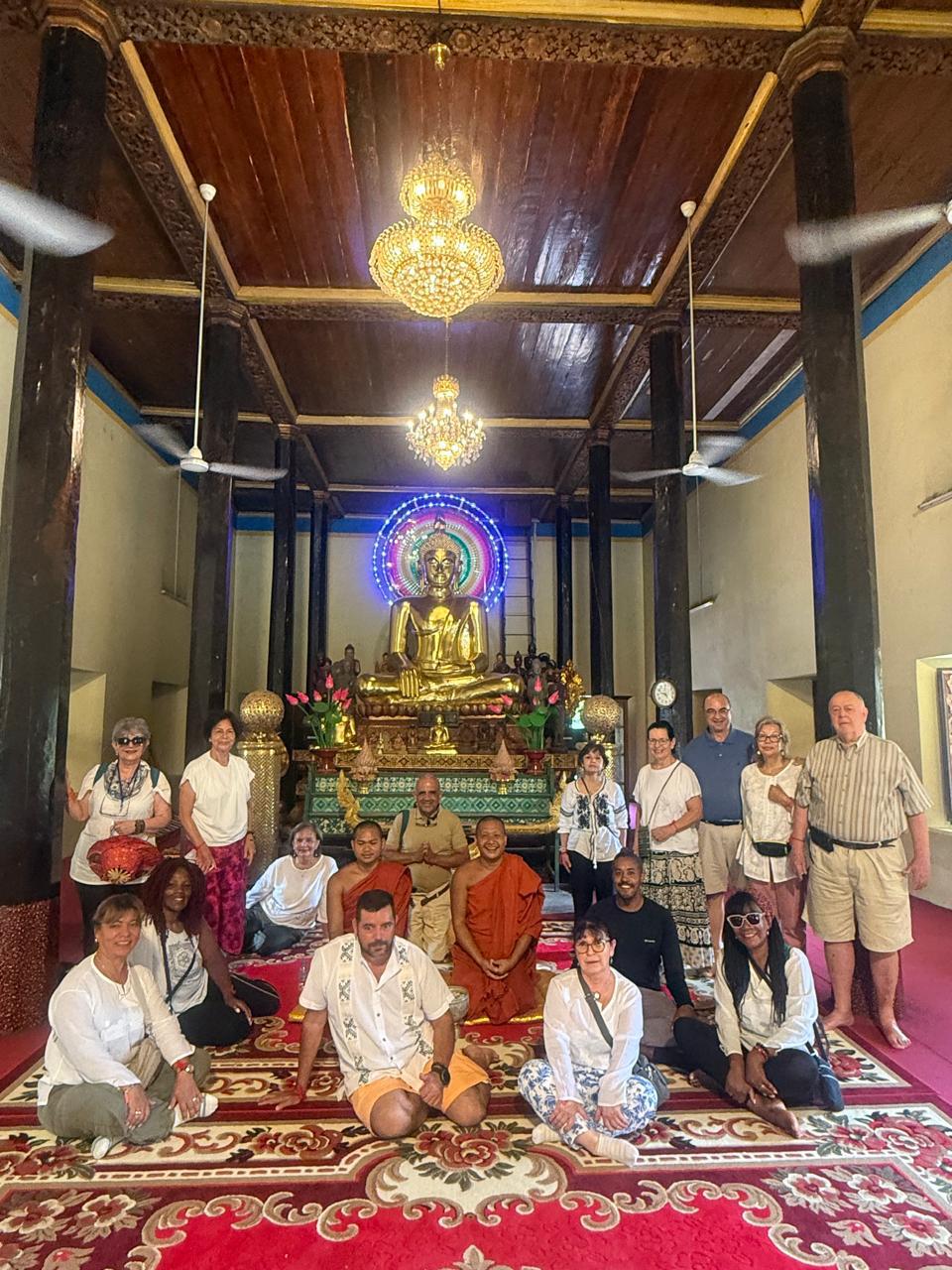 Interior dorado de templo budista con monjes en Sudeste Asiático